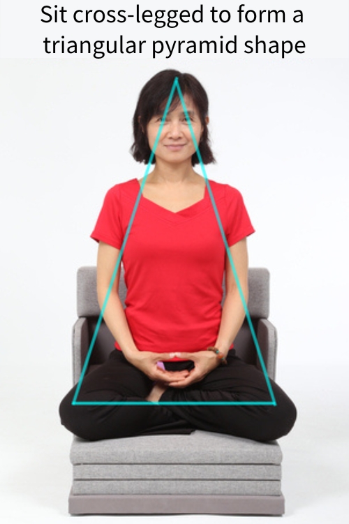 Sit cross-legged to form a triangular pyramid shape 